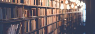 A well lit library and shelves filled with books